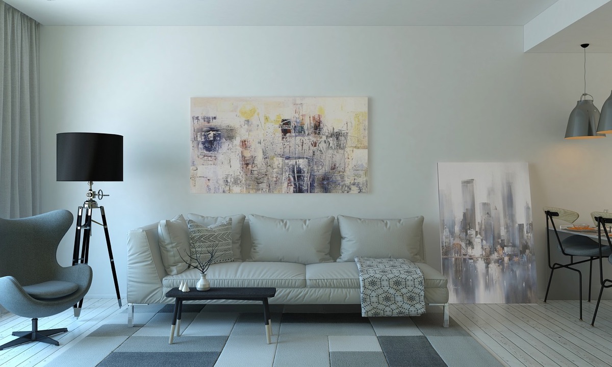 A minimalist table lamp emitting warm light on a side table next to a cozy armchair.