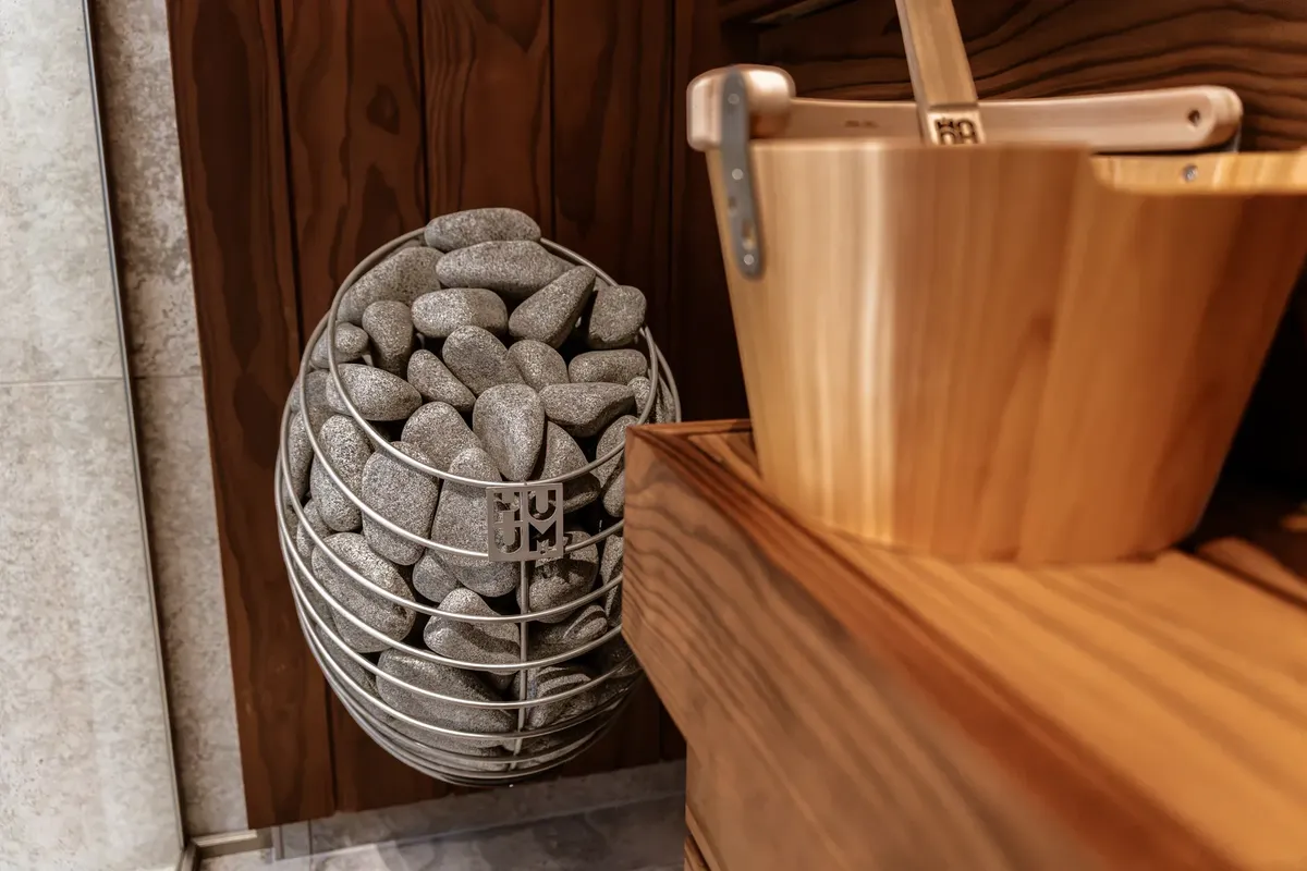 Explore the elegance of a modern indoor sauna featuring a Huum electric heater and sleek wooden panels.