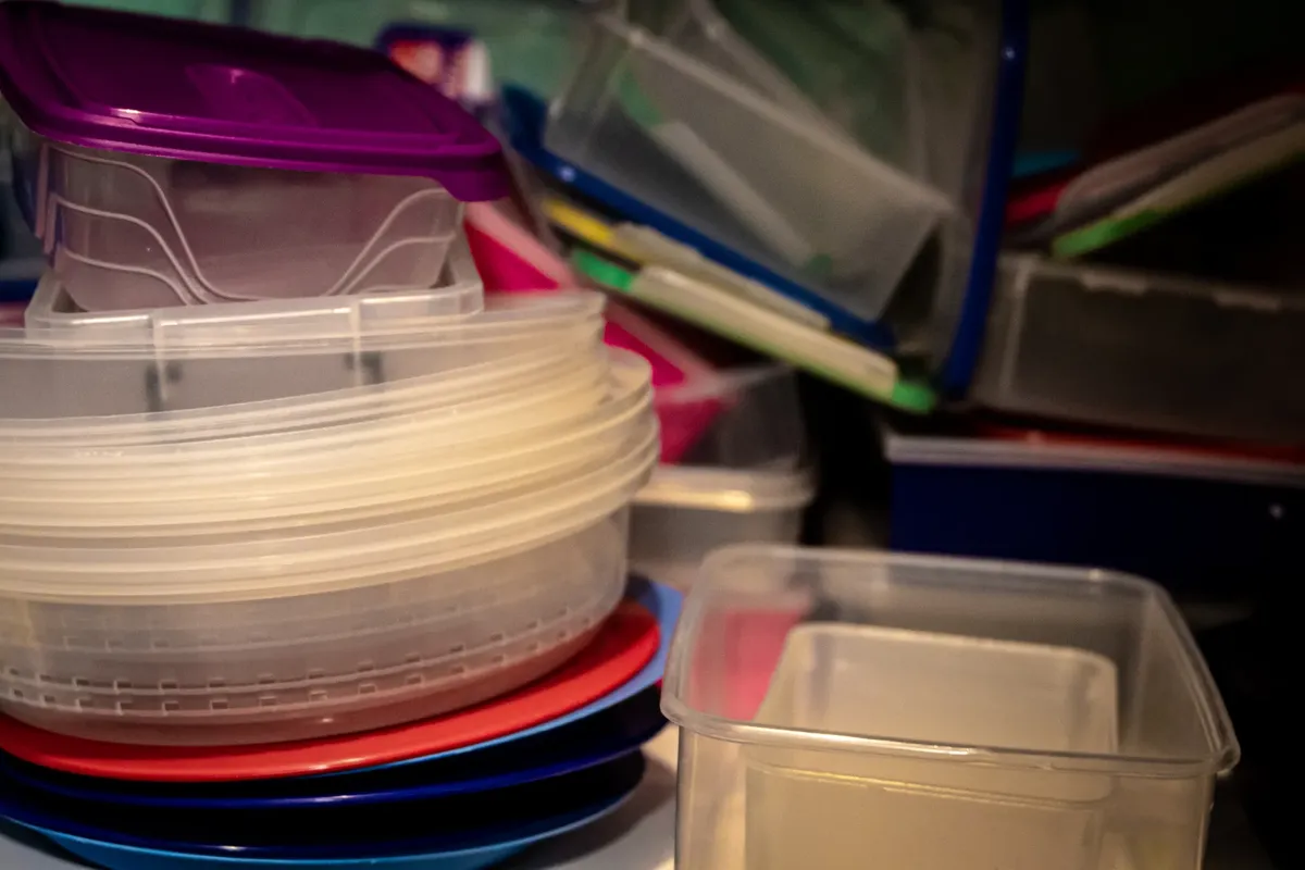 さまざまなプラスチックの収納容器が積み重なっており、キッチンスペースの整理に最適です。
