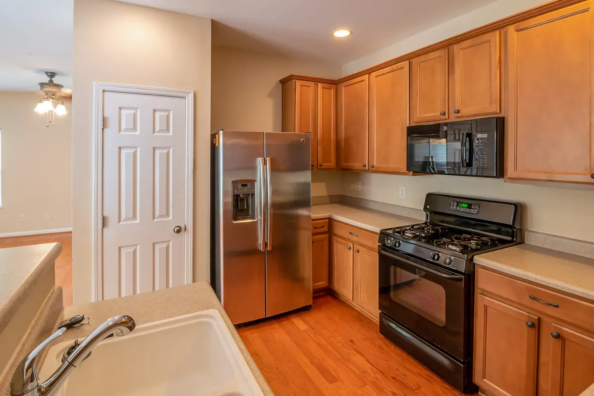 Contemporary kitchen featuring wooden cabinets, stainless steel refrigerator, and modern appliances.