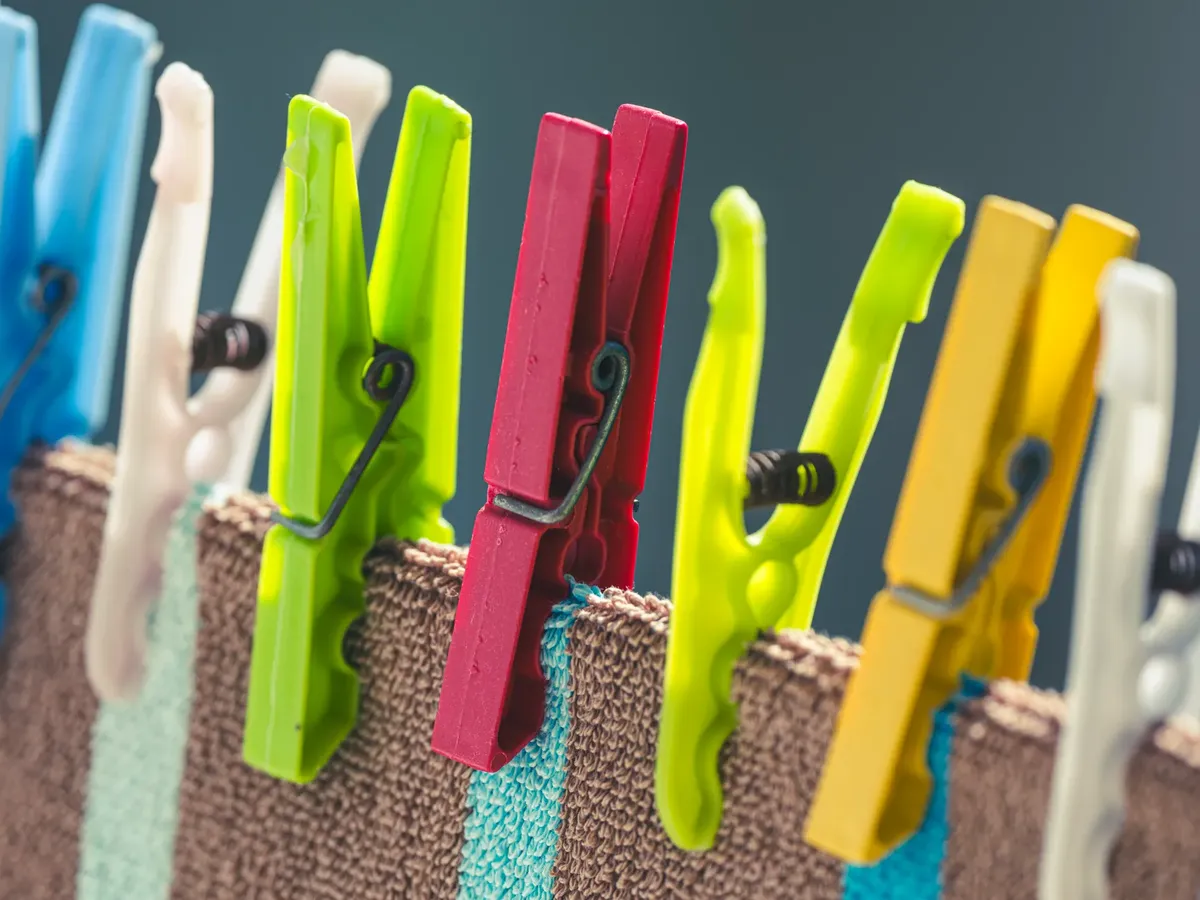 Vivid clothespins hang clothes on a line, showcasing laundry lifestyle essentials.